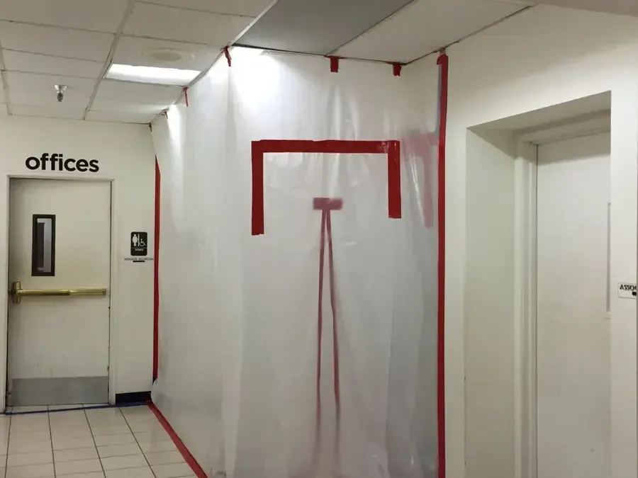 Plastic containment dividing an office corridor during drying