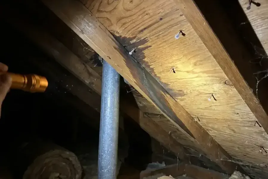 Dark water stain along an exposed attic rafter