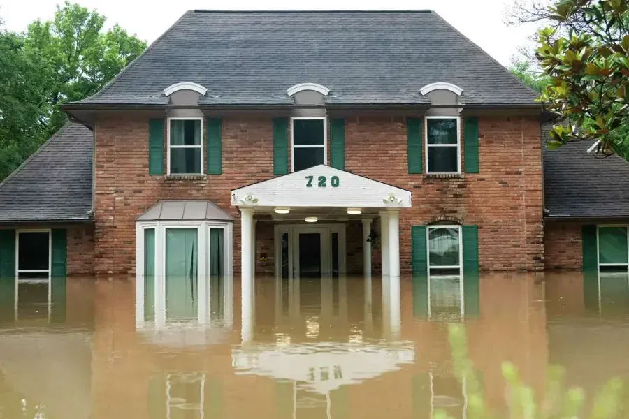 Brick home standing in brown flood water